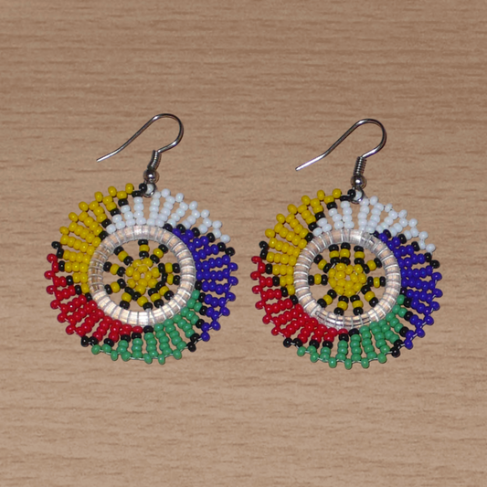 Boucles d'oreilles sud-africaines rondes à motifs traditionnels zoulous composées de perles de rocaille multicolores. Elles mesurent 5.5 cm de long et 4 cm de large, et se portent sur des oreilles percées.