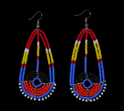 Longues boucles d'oreilles ethniques afro chic de tradition Massai composées de perles de rocaille multicolores. Elles mesurent 8.5 cm de long et 3.5 cm de large et se portent sur des oreilles percées.