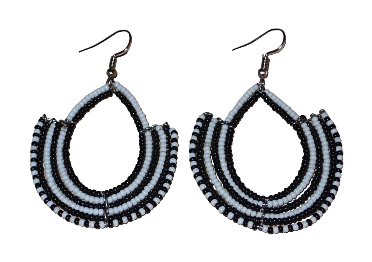 Boucles d'oreilles ethniques bicolores composées de perles de rocaille noires et blanches glissées sur des structures en fils de fer montés en forme d'ancres. Elles mesurent 7 cm de long et 4,5 cm de large et se portent sur des oreilles percées.