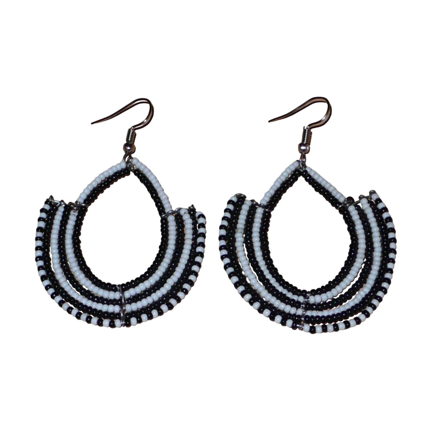 Boucles d'oreilles ethniques bicolores composées de perles de rocaille noires et blanches glissées sur des structures en fils de fer montés en forme d'ancres. Elles mesurent 7 cm de long et 4,5 cm de large et se portent sur des oreilles percées.