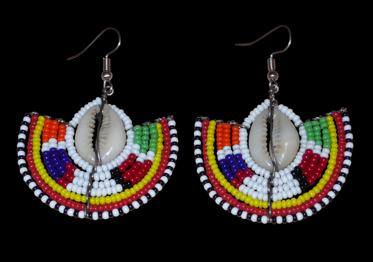 Apportez une touche de couleur et d'authenticité à votre style avec cette paire de boucles d'oreilles africaines issues de l'artisanat traditionnel Massai. Confectionnées à la main au Kenya, ces boucles d'oreilles ethniques se composent de perles de rocaille blanches et multicolores et de coquillages cauris. De taille moyenne, elles mesurent 6 cm de long et 4.5 cm de large, et se portent avec des crochets en acier inoxydable sur des oreilles percées.