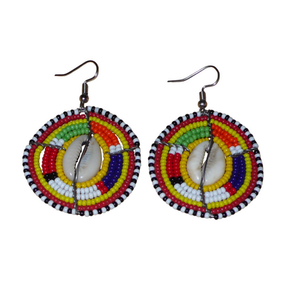 Ambiance exotique avec ces jolies boucles d'oreilles africaines à motifs ethniques traditionnels Massai de conception artisanale kenyane. Elles sont composées de perles de rocaille jaunes et multicolores et de coquillages cauris fixés sur des fils de fer montés en forme de boucliers Massai. Ces boucles d'oreilles de taille moyenne mesurent 6.5 cm de long et 4 cm de large ; elles se portent avec des crochets en acier inoxydable sur des oreilles percées.