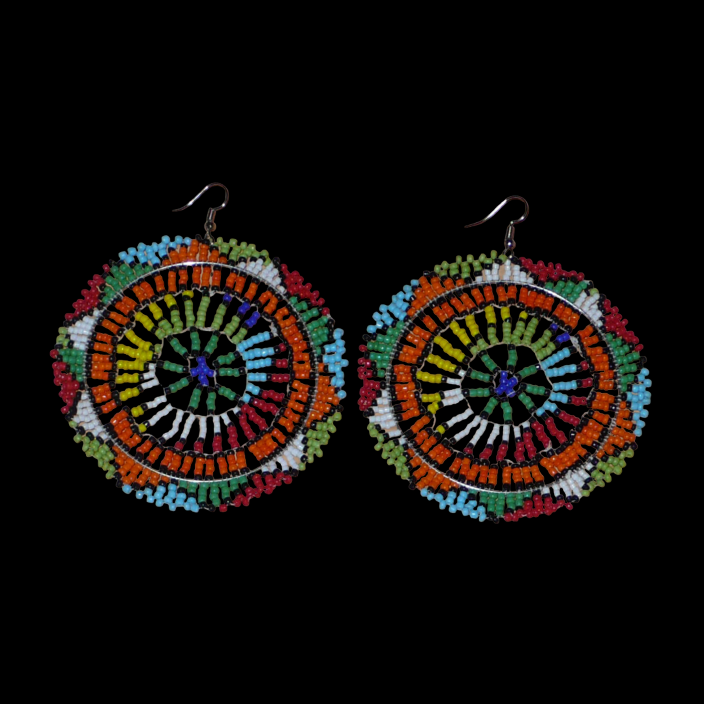 Boucles d'oreilles africaines surdimensionnées aux motifs traditionnels zoulous et couleurs rétro évoquant le style afro chic des années 70 : elles se composent de perles de rocaille multicolores et mesurent 10 cm de long et 8.5 cm de large ; elles se portent avec des crochets en acier inoxydable sur des oreilles percées.