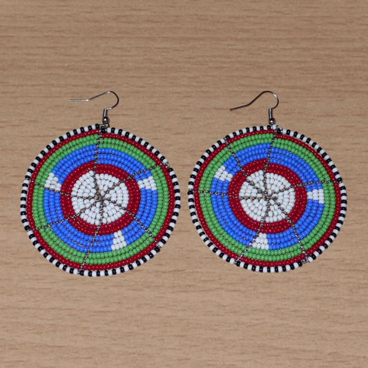 Boucles d'oreilles africaines ethniques Massai rondes composées de perles de rocaille bleues, vertes, rouges, blanches et noires. Elles mesurent 8 cm de long et 6,5 cm de large, et se portent sur des oreilles percées.