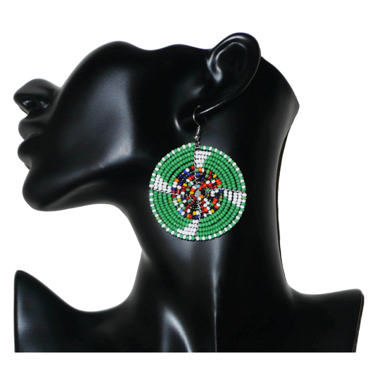 Ajoutez une touche ethnique afro bohème à votre look avec ces boucles d'oreilles africaines rondes confectionnées à la main dans la tradition artisanale Massai : elles se composent de perles de rocaille principalement vertes, puis blanches et multicolores glissées sur des structures circulaires en fils de fer.