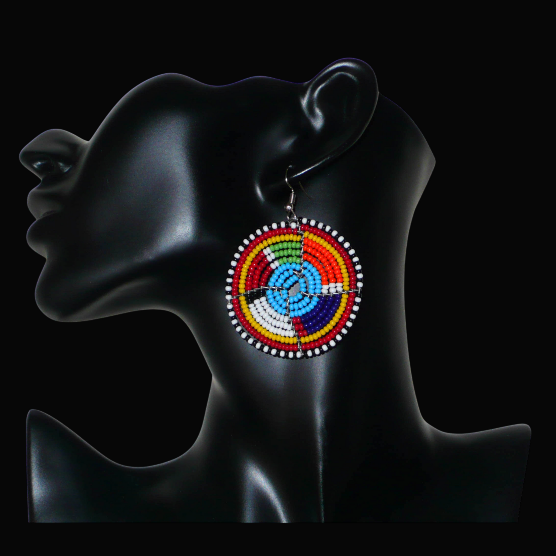 Boucles d'oreilles africaines bleues et multicolores à motifs ethniques traditionnels Massai, composées d'un tissage de perles de rocaille glissées sur des structures circulaires en fils de fer. De taille moyenne, ces boucles d'oreilles perlées mesurent 6.5 cm de long et 4.5 cm de large et se portent avec des crochets en acier inoxydable sur des oreilles percées.