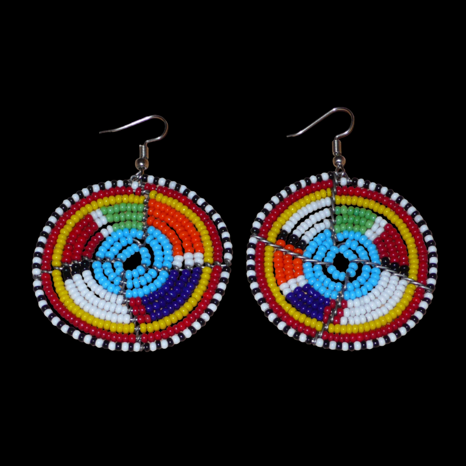 Boucles d'oreilles africaines bleues et multicolores à motifs ethniques traditionnels Massai, composées d'un tissage de perles de rocaille glissées sur des structures circulaires en fils de fer. De taille moyenne, ces boucles d'oreilles perlées mesurent 6.5 cm de long et 4.5 cm de large et se portent avec des crochets en acier inoxydable sur des oreilles percées.