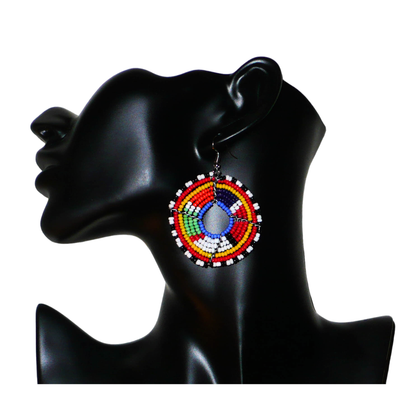Boucles d'oreilles africaines Massai en perles de rocaille multicolores enfilées sur des structures circulaires en fils de fer. Elles mesurent 6,5 cm de long et 4,5 cm de large.