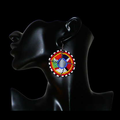 Boucles d'oreilles africaines Massai en perles de rocaille multicolores enfilées sur des structures circulaires en fils de fer. Elles mesurent 6,5 cm de long et 4,5 cm de large.