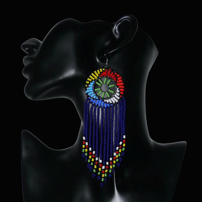 Boucles d'oreilles ethniques à franges fabriquées en Afrique du Sud composées de perles de rocaille bleu foncé, vertes et multicolores ; elles mesurent 14.5 cm de long et 4.5 cm de large.