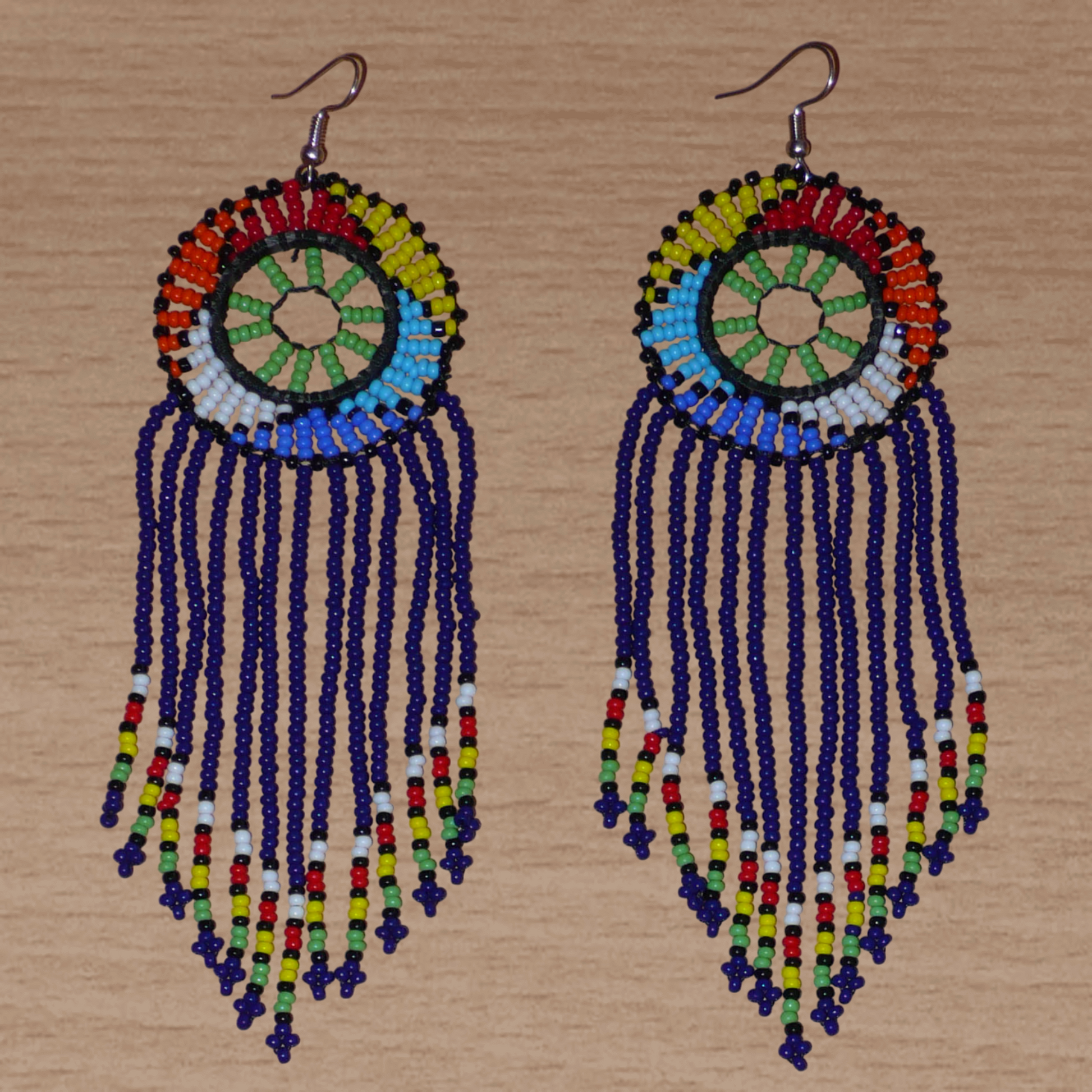 Boucles d'oreilles ethniques à franges fabriquées en Afrique du Sud composées de perles de rocaille bleu foncé, vertes et multicolores ; elles mesurent 14.5 cm de long et 4.5 cm de large.