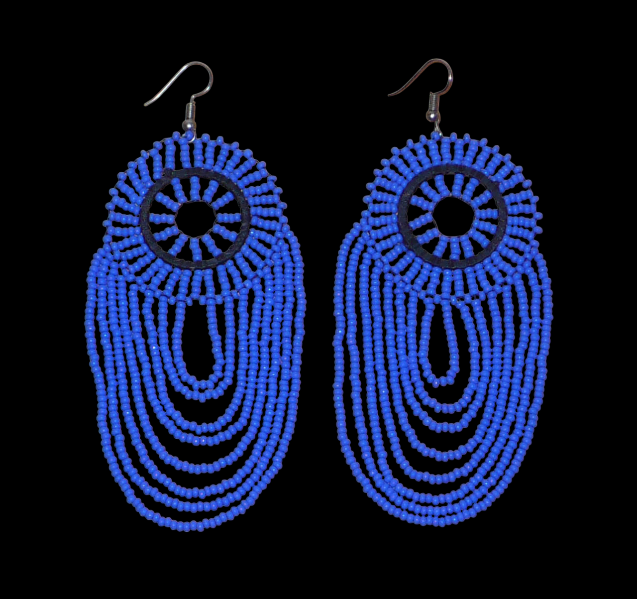 Longues boucles d'oreilles sud-africaines à franges perlées : de tradition artisanale zouloue, elles se composent d'un tissage de perles de rocaille bleues enfilées sur des fils de nylon fixés à un cercle de plastique noir. Cette paire de boucles d'oreilles aux accents ethniques mesure 12 cm de long et 4.5 cm de large et se porte avec des crochets en acier inoxydable sur des oreilles percées.