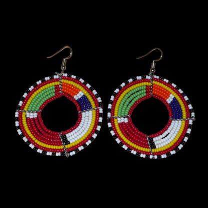 Boucles d'oreilles africaines rondes aux motifs et couleurs Massai composées de perles de rocaille rouges et multicolores enfilées sur sept rangées de fils de fer montés en forme de cercles. Elles mesurent 7,5 cm de long et 5,5 cm de large et se portent avec des crochets en acier inoxydable sur des oreilles percées.