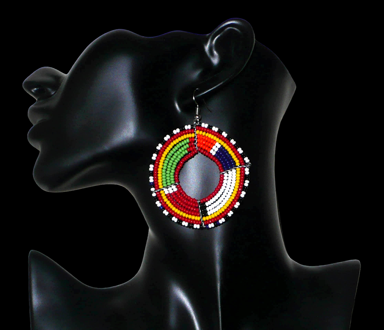 Boucles d'oreilles africaines rondes aux motifs et couleurs Massai composées de perles de rocaille rouges et multicolores enfilées sur sept rangées de fils de fer montés en forme de cercles. Elles mesurent 7,5 cm de long et 5,5 cm de large et se portent avec des crochets en acier inoxydable sur des oreilles percées.