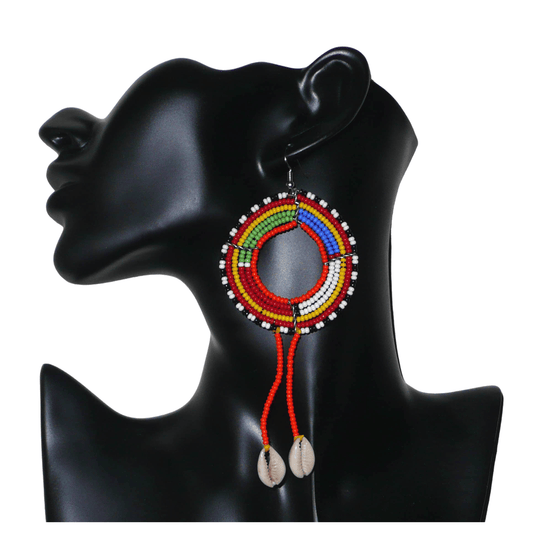 Longues boucles d'oreilles africaines Massai rondes en perles de rocaille orange et multicolores, prolongées de franges perlées ornées de coquillages cauris. Elles mesurent 12,5 cm de long et 5,5 cm de large.
