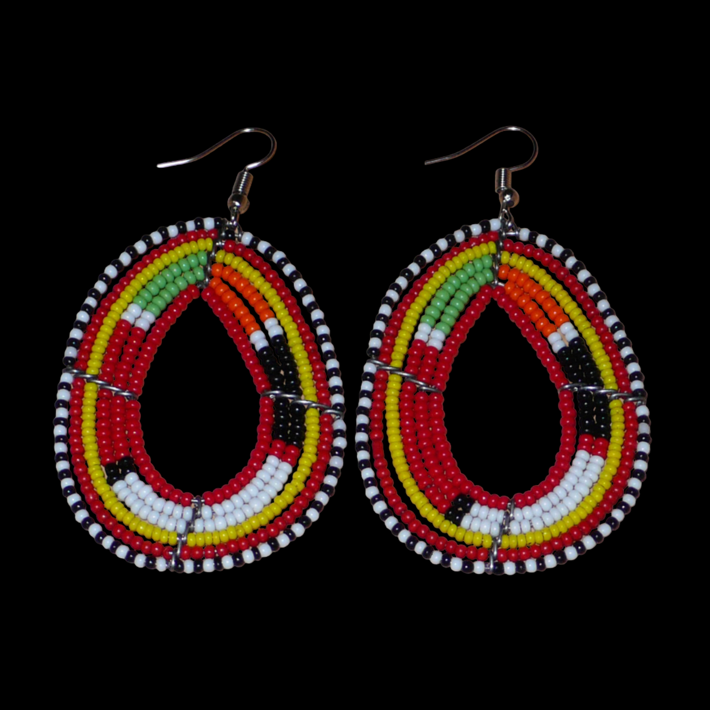 Boucles d'oreilles africaines aux motifs traditionnels Massai composées de perles de rocaille rouges et multicolores enfilées sur des fils de fer montés en forme de gouttes. Elles mesurent 7,5 cm de long et 4 cm de large et se portent avec des crochets en acier inoxydable.