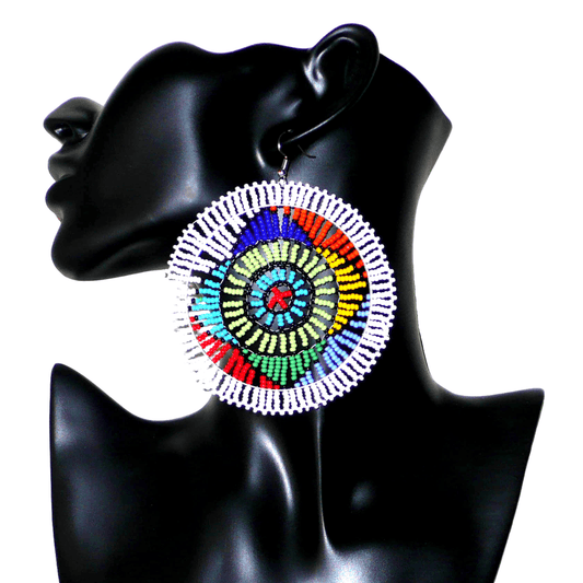 Boucles d'oreilles ethniques afro chic de tradition sud-africaine zouloue composées de perles de rocaille blanches et multicolores. Surdimensionnées, elles mesurent 10 cm de long et 8,5 cm de large, et se portent sur des oreilles percées.