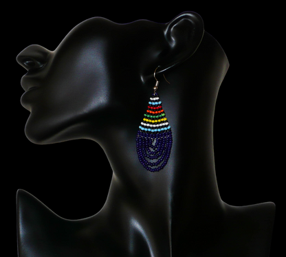 Boucles d'oreilles africaines zouloues en perles de rocaille bleu foncé et multicolores montées en forme de gouttes. Elles mesurent 7 cm de long et 2,5 cm de large, et se portent sur des oreilles percées.