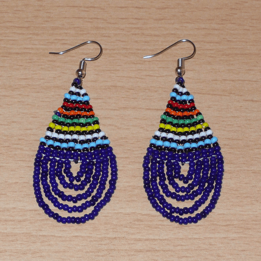 Boucles d'oreilles africaines zouloues en perles de rocaille bleu foncé et multicolores montées en forme de gouttes. Elles mesurent 7 cm de long et 2,5 cm de large, et se portent sur des oreilles percées.