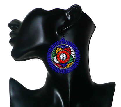 Boucles d'oreilles sud-africaines rondes à motifs ethniques zoulous composées de perles de rocaille bleues et multicolores. Elles mesurent 7,5 cm de long et 5,5 cm de large et se portent avec des crochets en acier inoxydable sur des oreilles percées.