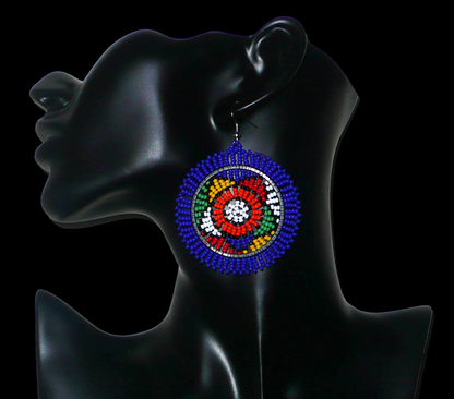 Boucles d'oreilles sud-africaines rondes à motifs ethniques zoulous composées de perles de rocaille bleues et multicolores. Elles mesurent 7,5 cm de long et 5,5 cm de large et se portent avec des crochets en acier inoxydable sur des oreilles percées.