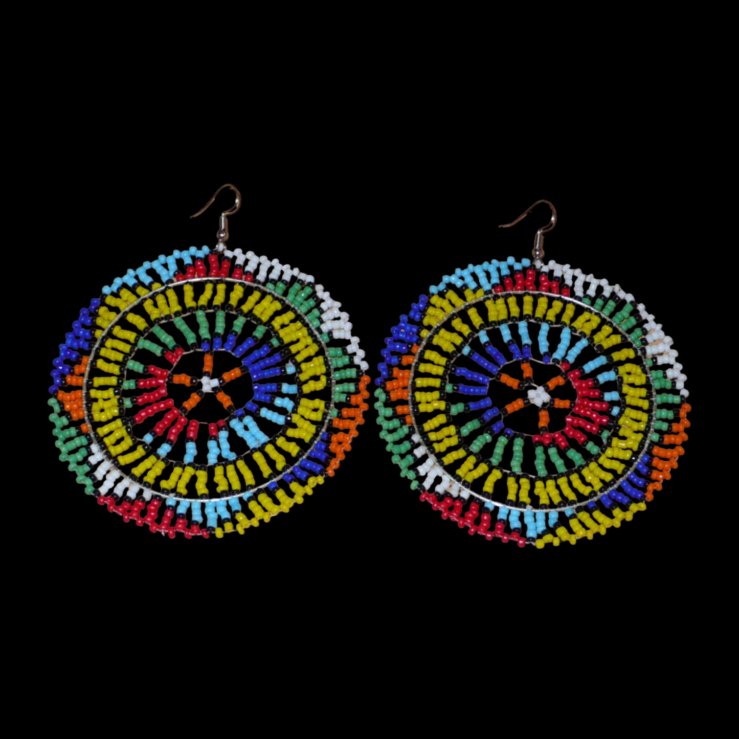 Boucles d'oreilles sud-africaines rondes au style afro chic des années 70. Elles se composent de perles de rocaille multicolores enfilées sur des fils de nylon fixés sur des structures circulaires. Surdimensionnées, elles mesurent 10 cm de long et 8,5 cm de large, et se portent sur des oreilles percées.