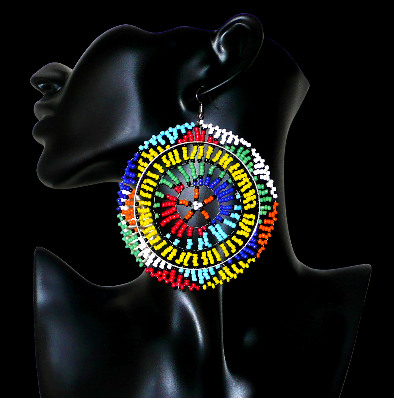 Boucles d'oreilles sud-africaines rondes au style afro chic des années 70. Elles se composent de perles de rocaille multicolores enfilées sur des fils de nylon fixés sur des structures circulaires. Surdimensionnées, elles mesurent 10 cm de long et 8,5 cm de large, et se portent sur des oreilles percées.