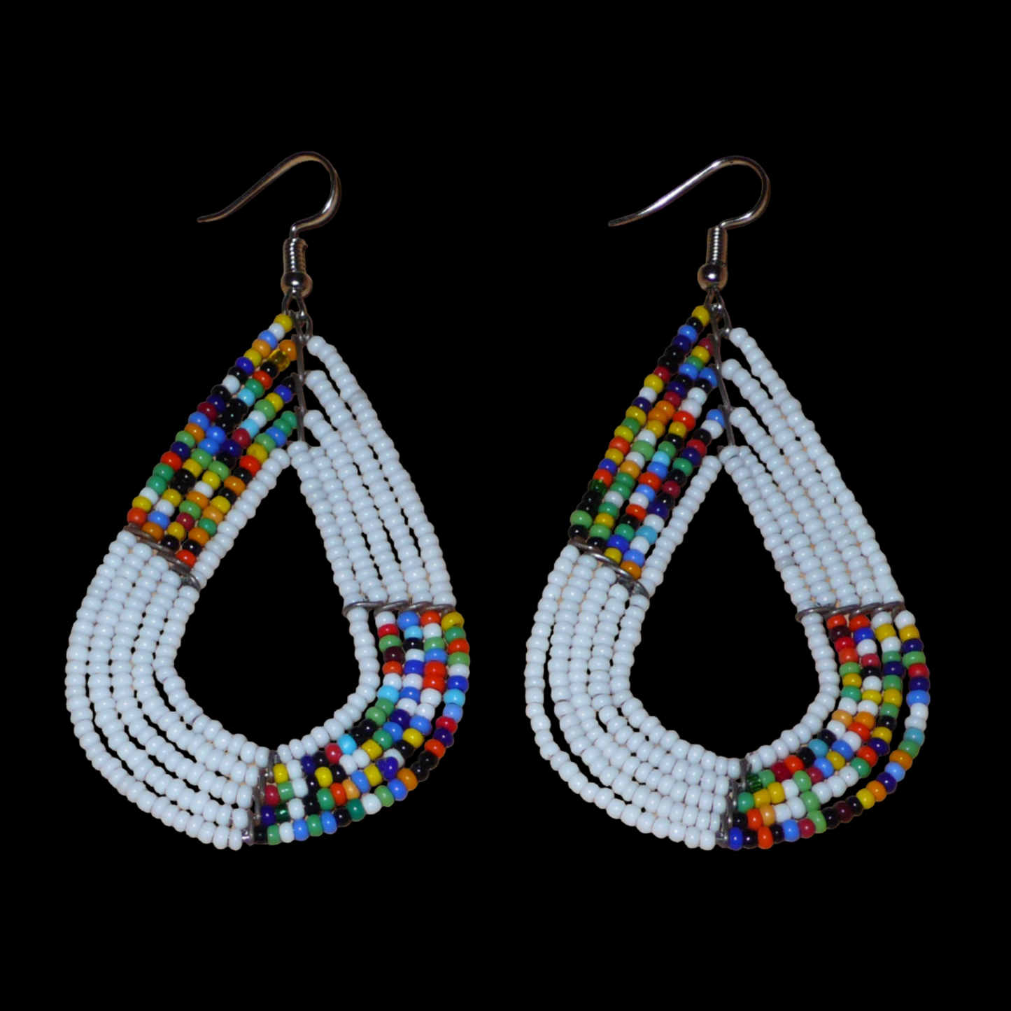 Boucles d'oreilles africaines multi-rangs blanches et multicolores aux accents évoquant le style bohème des années 70. Fabriquées au Kenya, elles se composent de perles de rocaille blanches et d'un mélange de perles multicolores glissées sur cinq rangées de fils de fer en forme de gouttes légèrement triangulaires. Ces boucles d'oreilles mesurent 8 cm de long et 4 cm de large ; elles se portent avec des crochets en acier inoxydable sur des oreilles percées.