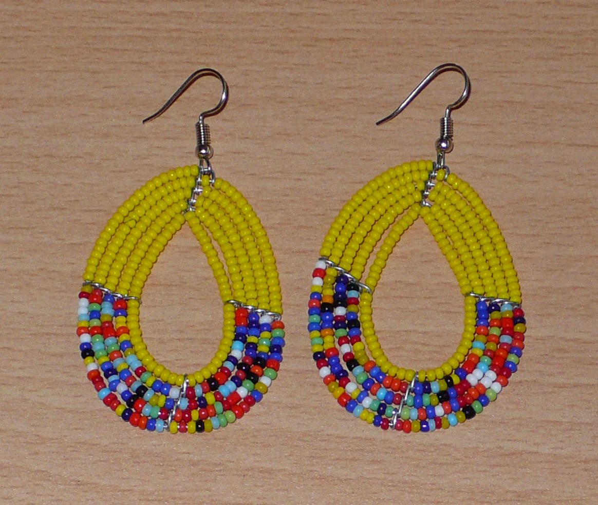 Boucles d'oreilles multi-rangs jaunes et multicolores faites de perles de rocaille enfilées sur cinq rangées de fils de fer montés en forme de gouttes. Elles mesurent 7 cm de long et 3,5 cm de large et se portent sur des oreilles percées.