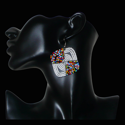 Boucles d'oreilles africaines Massai de confection artisanale kenyane composées de perles de rocaille blanches et d'un mélange de perles multicolores. Ces boucles d'oreilles aux accents exotiques mesurent 6.5 cm de long et 4.5 cm de large, et se portent avec des crochets en acier inoxydable sur des oreilles percées.