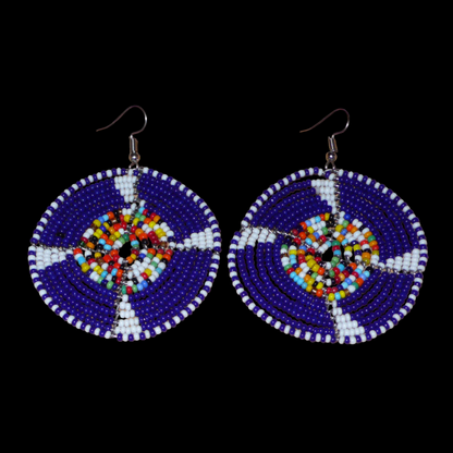 Apportez une touche ethnique afro bohème à votre look avec cette paire de boucles d'oreilles africaines rondes confectionnées en Afrique selon la tradition artisanale kenyane. Elles se composent de perles de rocaille principalement bleu marine, puis blanches et multicolores enfilées sur des structures circulaires en fils de fer. Elles mesurent 7.5 cm de long et 5.5 cm de large, et se porte avec des crochets en acier inoxydable sur des oreilles percées.