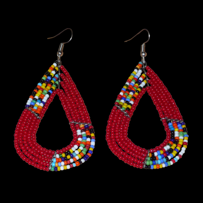 Boucles d'oreilles africaines Massai rouges et multicolores aux accents évoquant le style boho chic des années 70. Confectionnées au Kenya, elles se composent de perles de rocaille rouges et d'un mélange de perles multicolores glissées sur cinq rangées de fils de fer en forme de gouttes légèrement triangulaires. Ces boucles d'oreilles mesurent 8 cm de long et 4 cm de large ; elles se portent avec des crochets en acier inoxydable sur des oreilles percées.