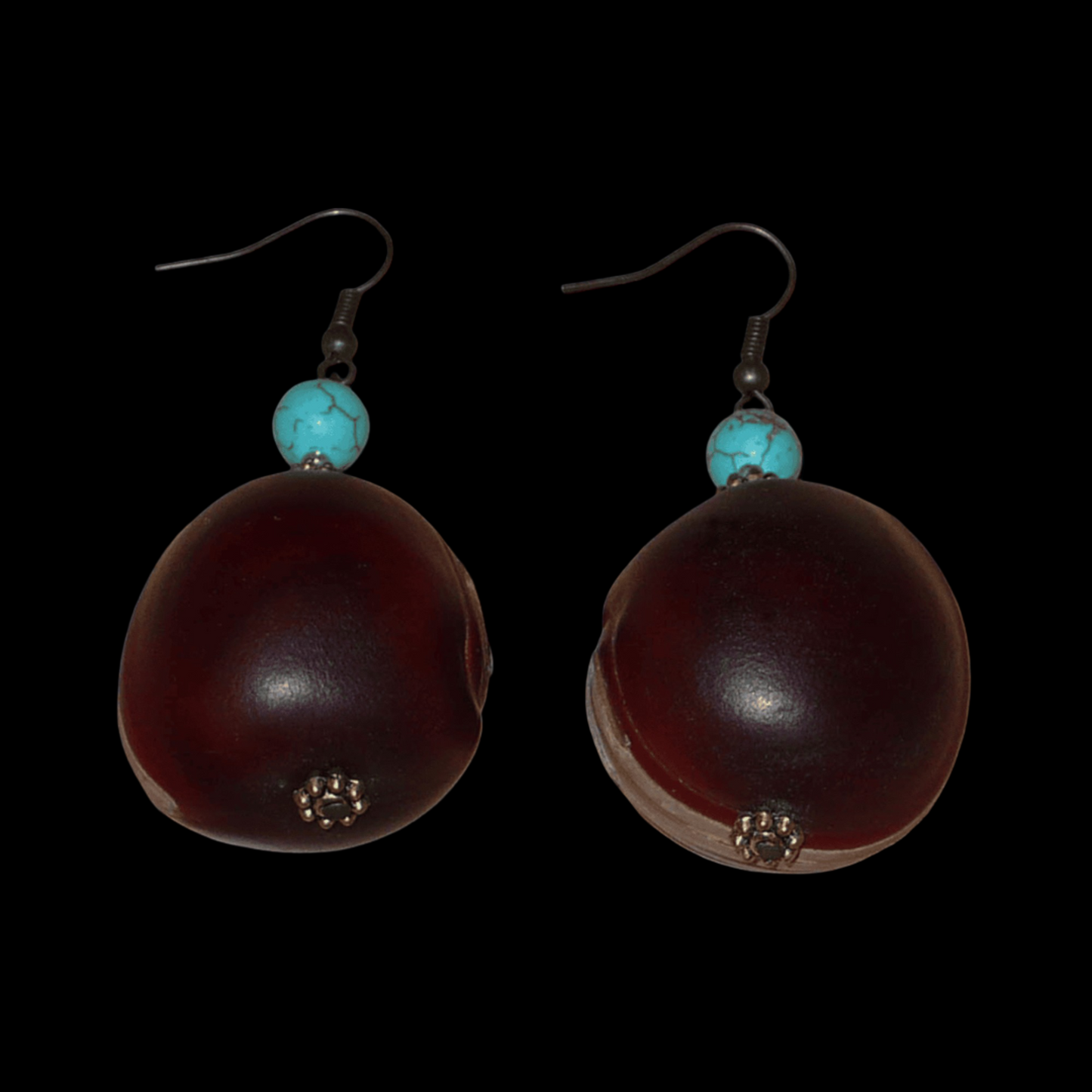 Boucles d'oreilles exotiques composées de graines tropicales ("Œil de bœuf") et de perles turquoises et dorées. Assez lourdes et de taille moyenne, ces boucles d'oreilles mesurent 6 cm de long et 3 cm de large ; elles se portent avec des crochets en acier inoxydable sur des oreilles percées.