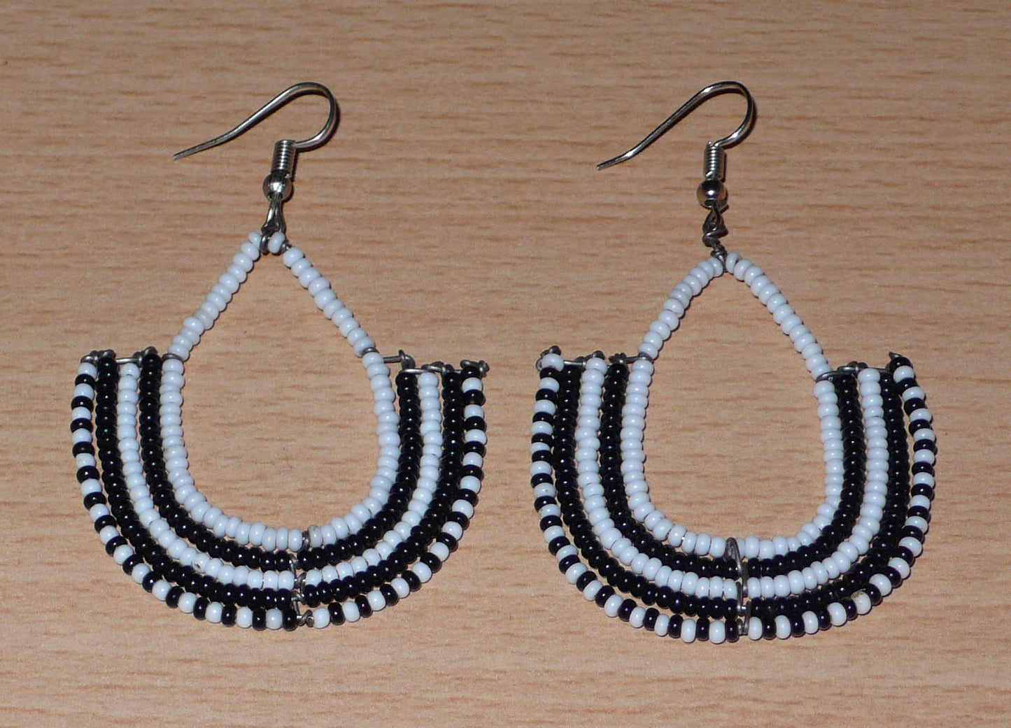 Boucles d'oreilles bicolores ethniques afro chic, de fabrication artisanale kenyane, composées de perles de rocaille blanches et noires montées en forme d'ancres.