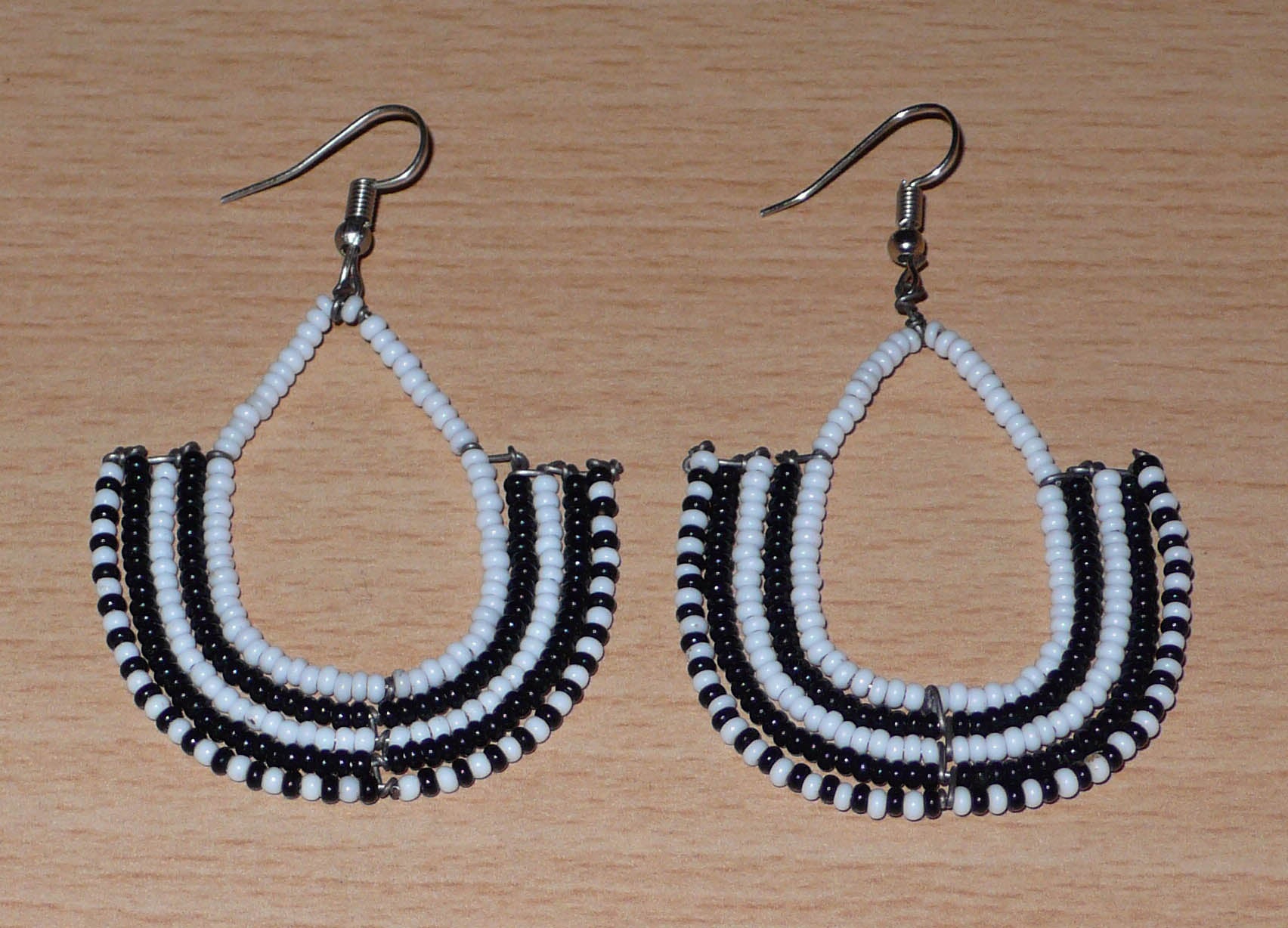 Boucles d'oreilles bicolores ethniques afro chic, de fabrication artisanale kenyane, composées de perles de rocaille blanches et noires montées en forme d'ancres.