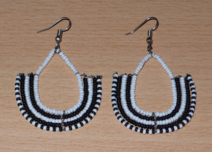 Boucles d'oreilles bicolores ethniques afro chic, de fabrication artisanale kenyane, composées de perles de rocaille blanches et noires montées en forme d'ancres.