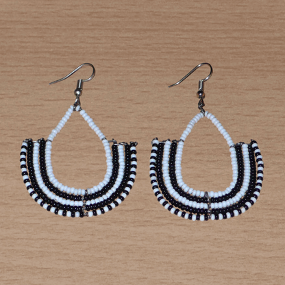 Boucles d'oreilles bicolores ethniques afro chic, de fabrication artisanale kenyane, composées de perles de rocaille blanches et noires montées en forme d'ancres.