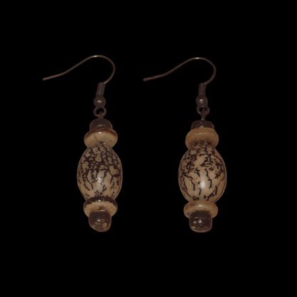 Boucles d'oreilles antillaises composées de perles et de graines organiques. De taille moyenne, elles mesurent 5 cm de long et 1,5 cm de large, et se portent avec des crochets sur des oreilles percées.