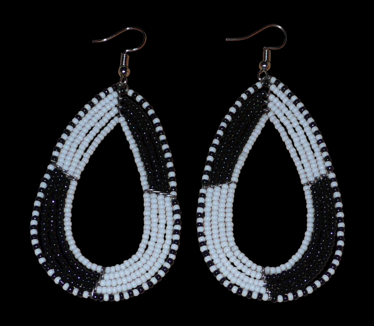 Longues boucles d'oreilles kenyanes en perles de rocaille blanches et noires enfilées sur plusieurs rangées de fils de fer montés en forme de gouttes. Ces boucles d'oreilles bicolores mesurent 8 cm de long et 4 cm de large et se portent avec des crochets en acier inoxydable sur des oreilles percées.