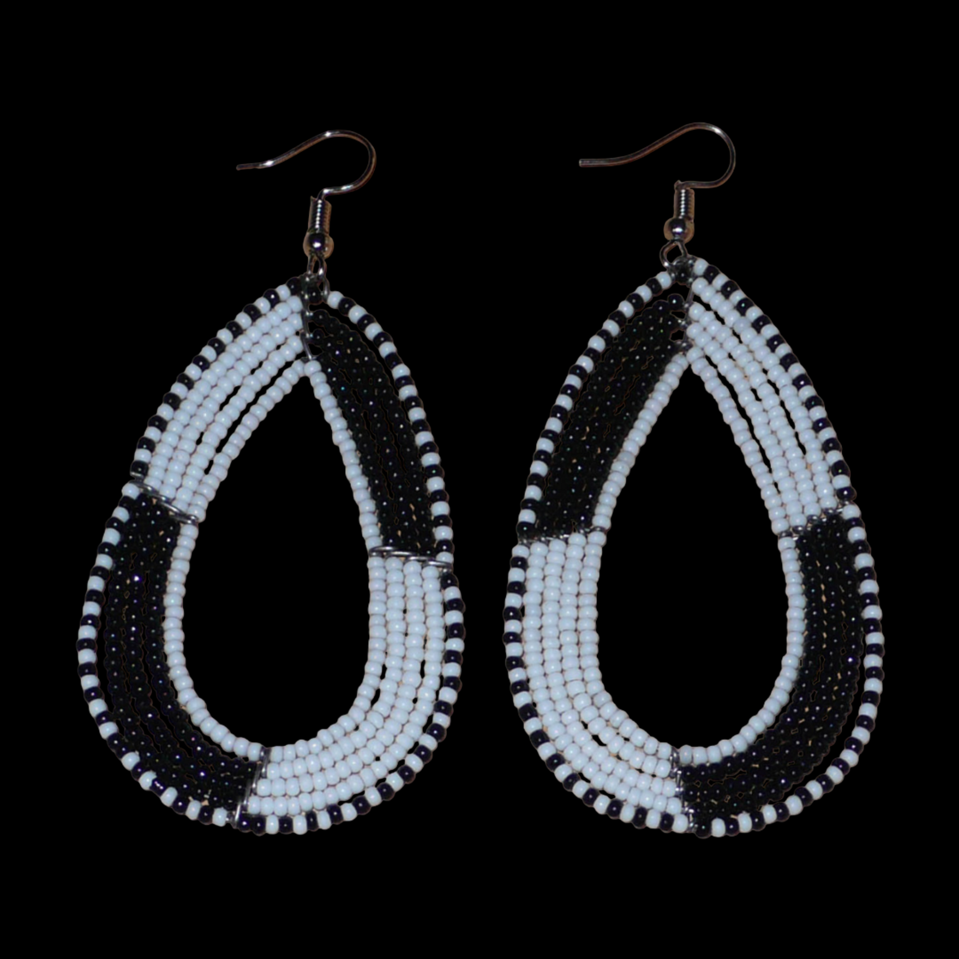 Longues boucles d'oreilles kenyanes en perles de rocaille blanches et noires enfilées sur plusieurs rangées de fils de fer montés en forme de gouttes. Ces boucles d'oreilles bicolores mesurent 8 cm de long et 4 cm de large et se portent avec des crochets en acier inoxydable sur des oreilles percées.
