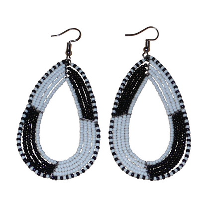 Longues boucles d'oreilles kenyanes en perles de rocaille blanches et noires enfilées sur plusieurs rangées de fils de fer montés en forme de gouttes. Ces boucles d'oreilles bicolores mesurent 8 cm de long et 4 cm de large et se portent avec des crochets en acier inoxydable sur des oreilles percées.