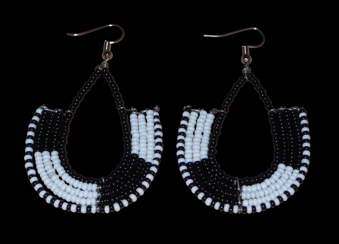 Boucles d'oreilles bicolores kenyanes en forme d'ancres, composées de perles de rocaille noires et blanches. Elles mesurent 7 cm de long et 4 cm de large, et se portent sur des oreilles percées.