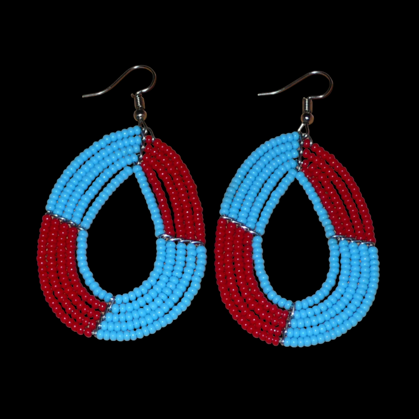 Boucles d'oreilles bicolores rouges et bleues en forme de gouttes composées de perles de rocaille. Elles mesurent 7,5 cm de long et 4 cm de large et se portent avec des crochets sur des oreilles percées. 