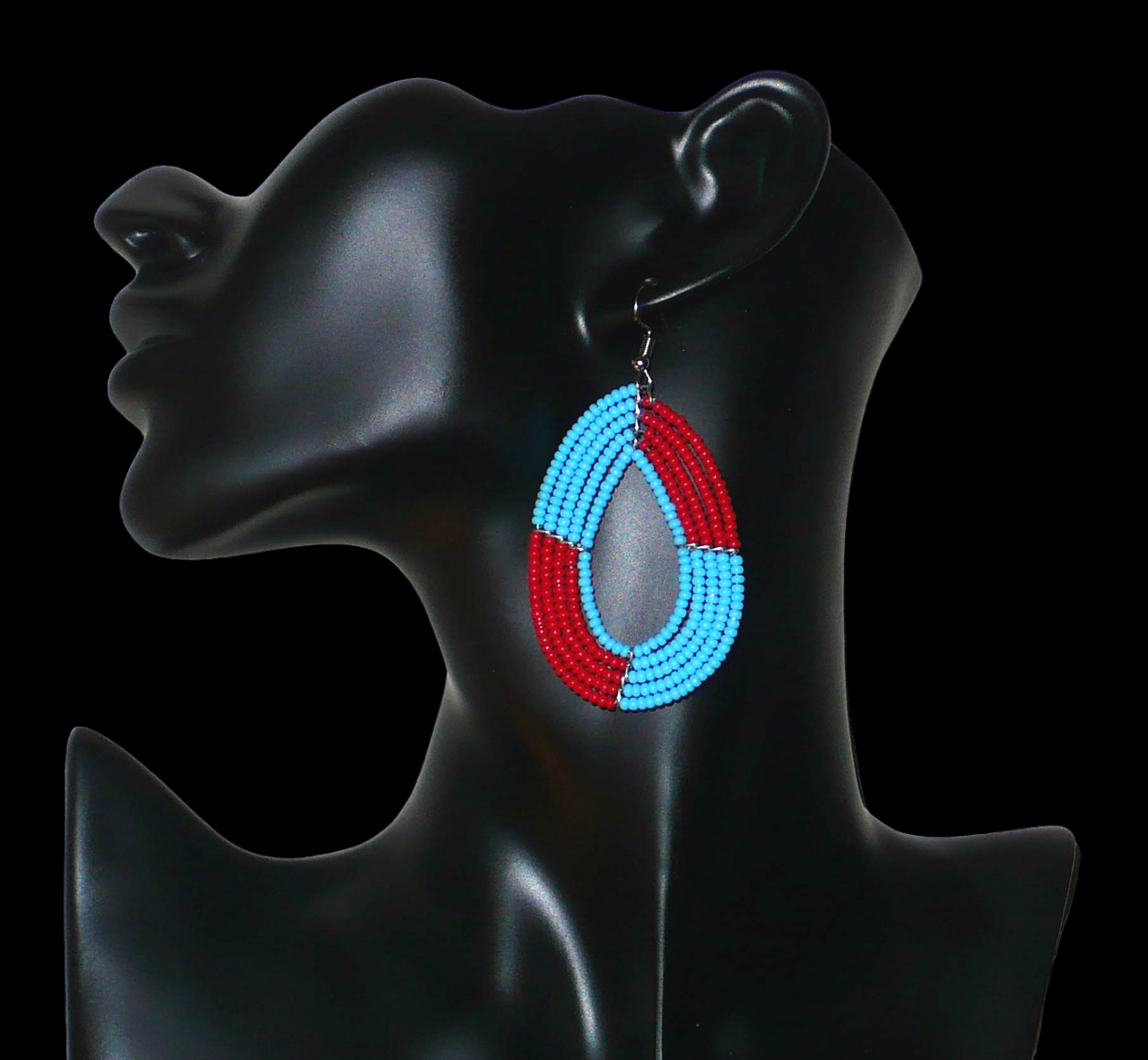 Boucles d'oreilles bicolores rouges et bleues en forme de gouttes composées de perles de rocaille. Elles mesurent 7,5 cm de long et 4 cm de large et se portent avec des crochets sur des oreilles percées. 
