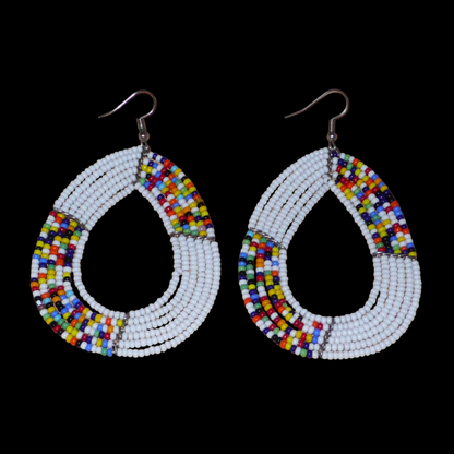 Longues et larges boucles d'oreilles multi-rangs blanches et multicolores faites de perles de rocaille montées en forme de gouttes. Ces boucles d'oreilles mesurent 8,5 cm de long et 5 cm de large et se portent avec de crochets en acier inoxydable sur des oreilles percées.