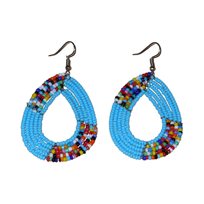 Boucles d'oreilles ethniques bleues et multicolores en forme de gouttes : de fabrication artisanale kenyane, elles se composent de perles de rocaille bleu ciel et d'un mélange de perles multicolores enfilées sur cinq rangées de fils de fer. De taille moyenne, elles mesurent 7.5 cm de long et 4 cm de large ; elles se portent avec des crochets en acier inoxydable sur des oreilles percées.
