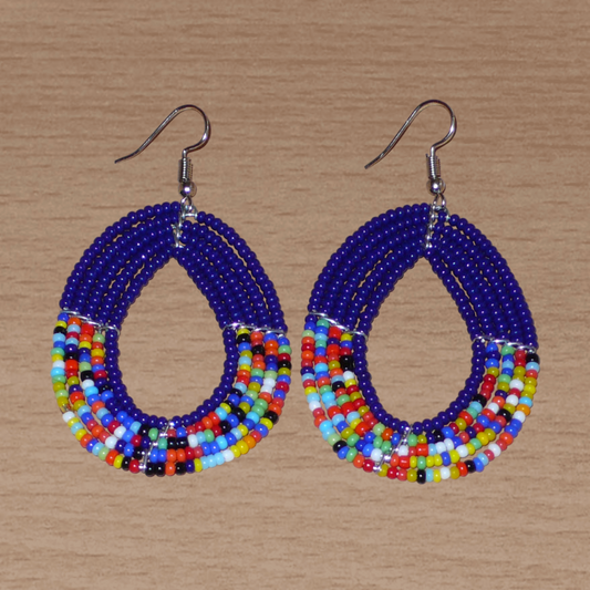 Boucles d'oreilles multi-rangs bleu marine et multicolores en forme de gouttes et composées de perles de rocailles. Elles mesurent 7 cm de long et 4 cm de large et se portent avec des crochets en acier inoxydable sur des oreilles percées.