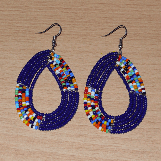 Boucles d'oreilles afro bohème bleu marine et multicolores en forme de gouttes composées de perles de rocaille. Elles mesurent 7,5 cm de long et 4 cm de large, et se portent sur des oreilles percées.