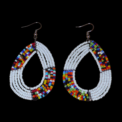 Boucles d'oreilles ethniques fabriquées au Kenya faites de perles de rocaille blanches et multicolores enfilées sur cinq rangées de fils de fer montés en forme de gouttes. Elles mesurent 8 cm de long et 4,5 cm de large et se portent sur des oreilles percées.