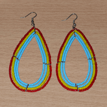 Longues et larges boucles d'oreilles aux couleurs exotiques composées de perles bleu turquoise, jaunes et rouges translucides enfilées sur quatre rangées de fils de fer montés en forme de gouttes. Ces boucles d'oreilles surdimensionnées mesurent 9,5 cm de long et 4,5 cm de large ; elles se portent avec des crochets sur des oreilles percées.